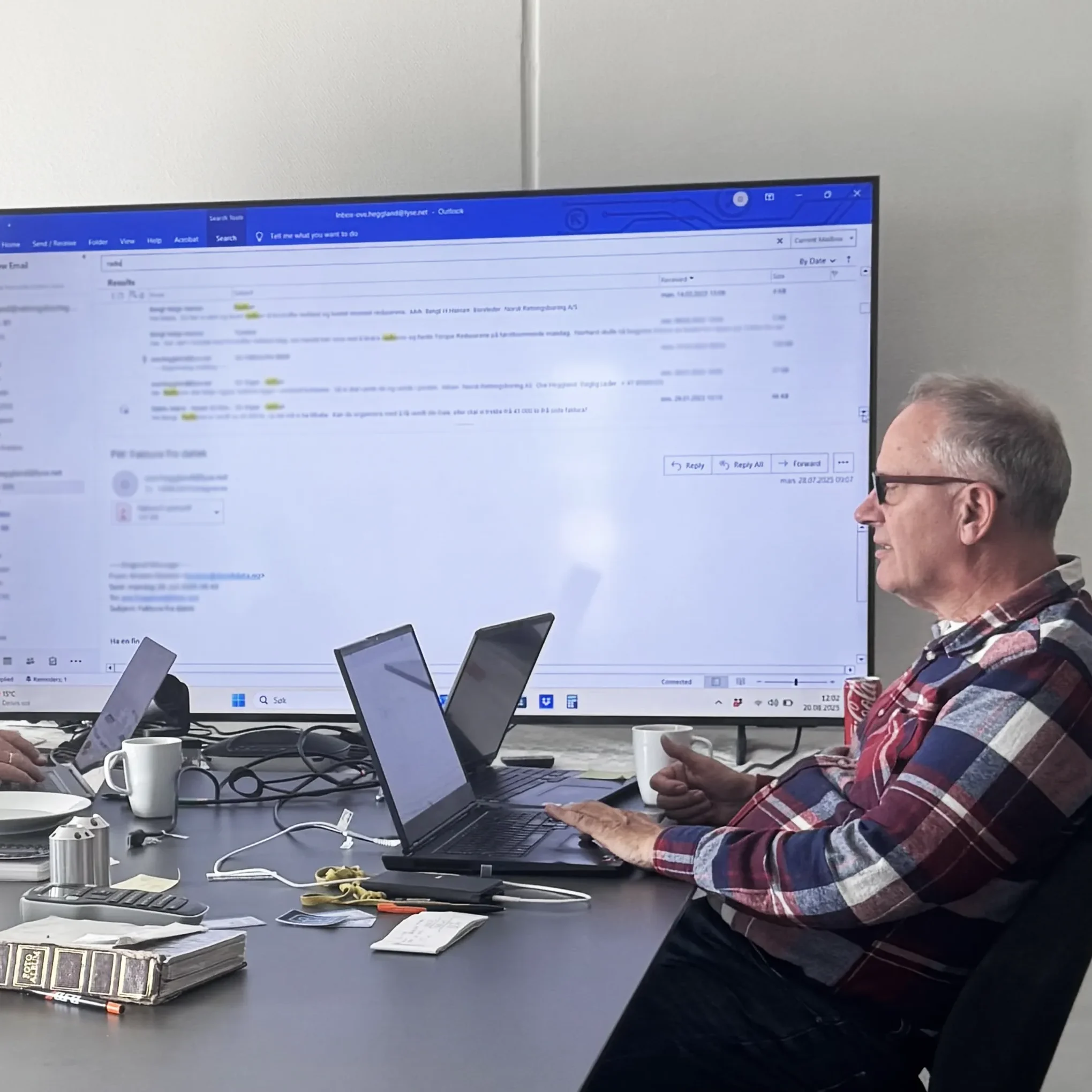 Ingeniør foran storskjerm og bærbar PC under planlegging av boreoperasjon.